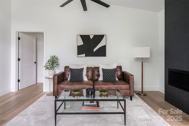 476 Upper Grassy Branch Rd, Asheville, NC 28805 - living area with wood finished floors, ceiling fan, vaulted ceiling, baseboards, and a large fireplace