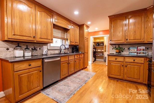 kitchen featuring a sink, dark countertops, brown cabinets, and dishwasher