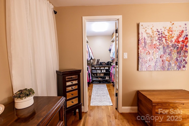 hall with baseboards and wood finished floors