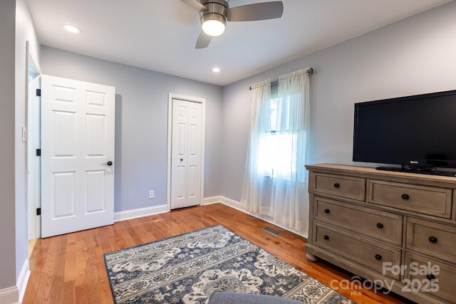 bedroom featuring baseboards, ceiling fan, light wood finished floors, and visible vents