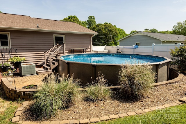 view of swimming pool with central air condition unit, fence, and a fenced in pool