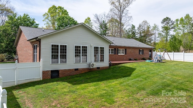 rear view of property featuring a fenced backyard, a yard, crawl space, and a shingled roof
