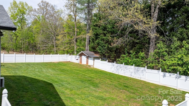 view of yard with an outdoor structure, a fenced backyard, and a storage unit