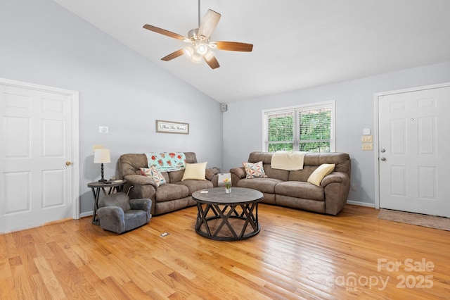 living area featuring light wood finished floors, ceiling fan, and high vaulted ceiling