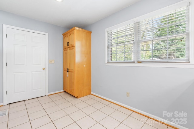 unfurnished bedroom featuring light tile patterned flooring, baseboards, and visible vents