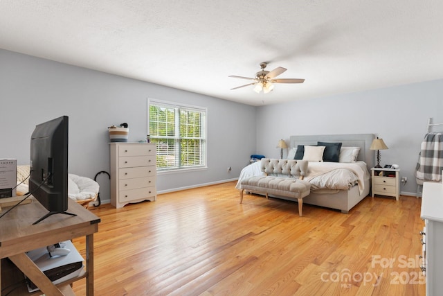 bedroom featuring baseboards, ceiling fan, and light wood finished floors