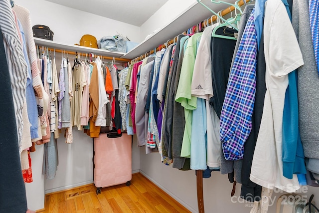 spacious closet featuring wood finished floors and visible vents