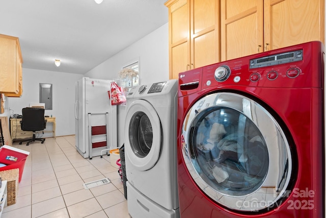 laundry room featuring cabinet space, electric panel, light tile patterned floors, and washer and dryer
