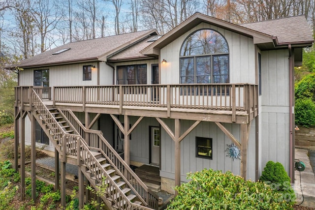 back of house featuring a deck, stairway, and a shingled roof
