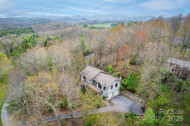 drone / aerial view with a mountain view and a wooded view