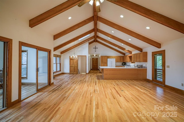 unfurnished living room featuring recessed lighting, light wood-style flooring, baseboards, and vaulted ceiling with beams