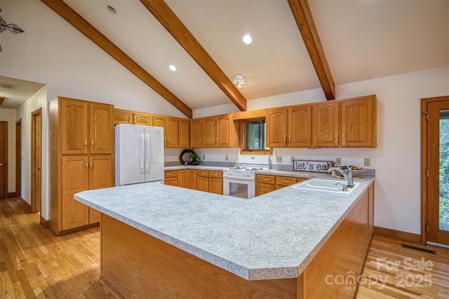kitchen with baseboards, white appliances, visible vents, a sink, and beam ceiling