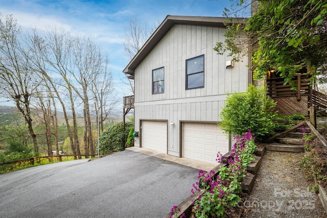 view of side of home with an attached garage and driveway