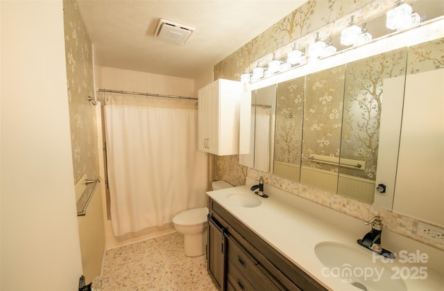 bathroom with double vanity, toilet, visible vents, and a sink