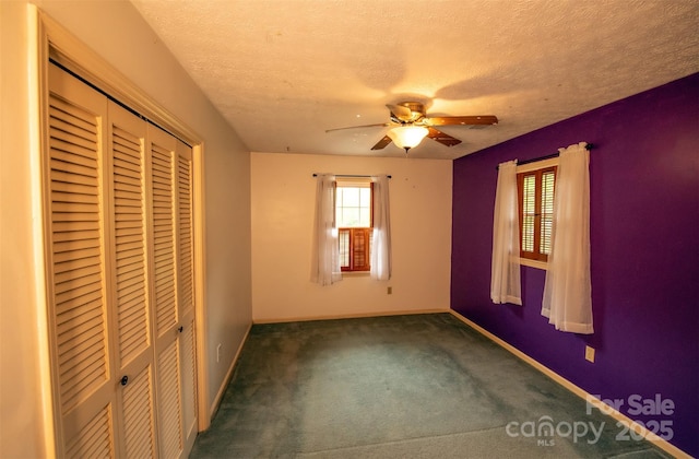 unfurnished bedroom with baseboards, carpet, a closet, and a textured ceiling