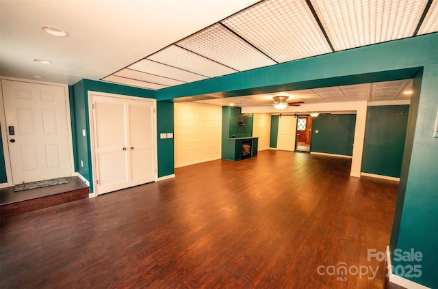 unfurnished living room featuring ceiling fan, a fireplace, wood finished floors, baseboards, and recessed lighting