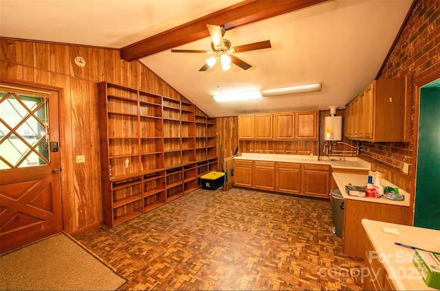 kitchen with wooden walls, lofted ceiling with beams, light countertops, built in shelves, and water heater