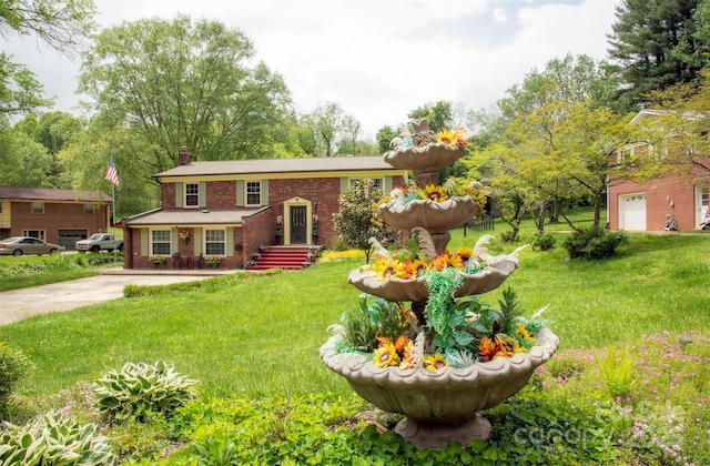 bi-level home featuring brick siding, a chimney, and a front lawn