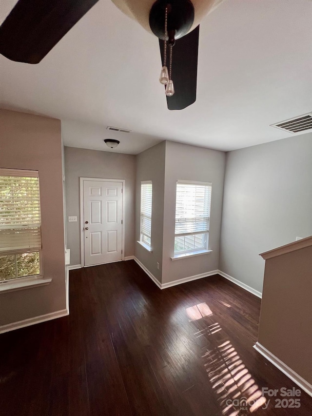foyer featuring baseboards, visible vents, and wood finished floors