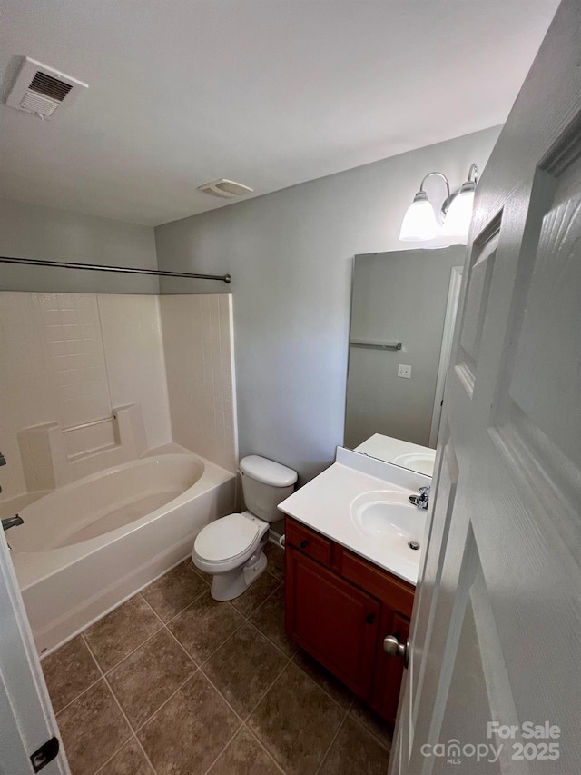 bathroom with visible vents, vanity, toilet, tile patterned floors, and shower / washtub combination