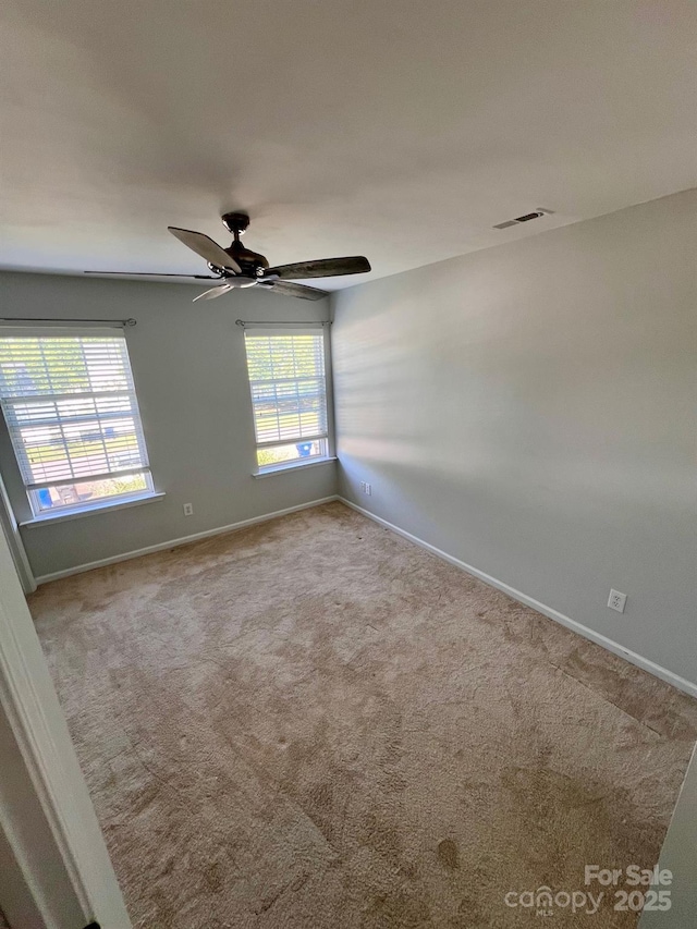 unfurnished room featuring a ceiling fan, baseboards, visible vents, and carpet
