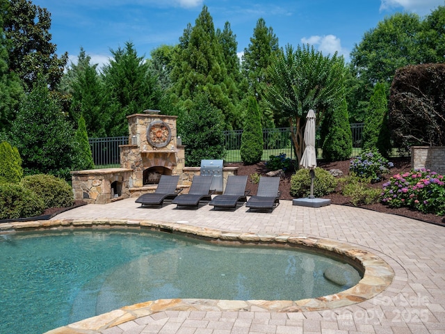8904 Woodhall Lake Dr, Waxhaw, NC 28173 - outdoor pool featuring fence, a patio, and an outdoor stone fireplace