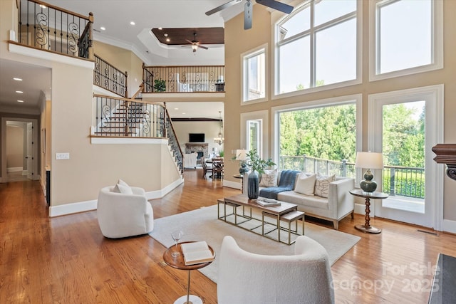 8904 Woodhall Lake Dr, Waxhaw, NC 28173 - living room featuring crown molding, a high ceiling, a ceiling fan, baseboards, and stairway
