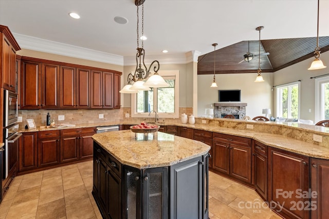8904 Woodhall Lake Dr, Waxhaw, NC 28173 - kitchen with light stone counters, appliances with stainless steel finishes, a sink, a fireplace, and decorative backsplash