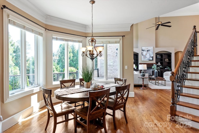 8904 Woodhall Lake Dr, Waxhaw, NC 28173 - dining space featuring crown molding, light wood-type flooring, stairs, and a notable chandelier