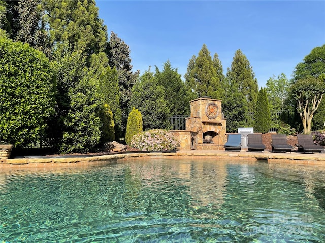 8904 Woodhall Lake Dr, Waxhaw, NC 28173 - view of swimming pool featuring a patio and an outdoor stone fireplace