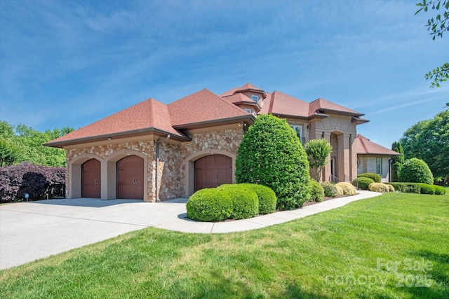 8904 Woodhall Lake Dr, Waxhaw, NC 28173 - view of front of house with stone siding, an attached garage, driveway, and a front yard
