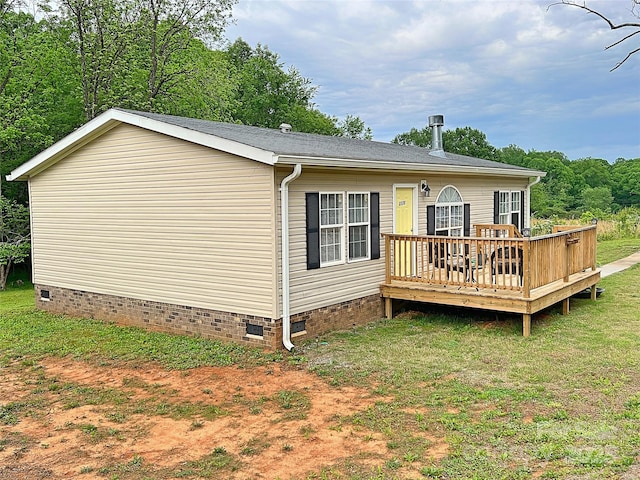 rear view of house with a yard, a deck, and crawl space