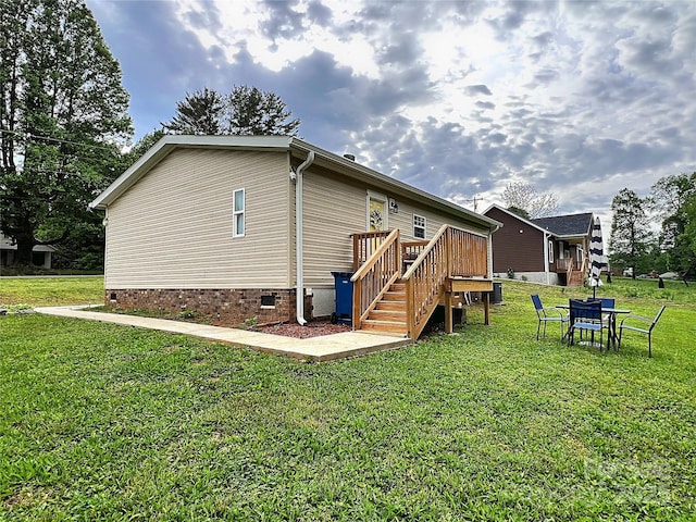 back of house featuring a lawn, stairway, a deck, and crawl space