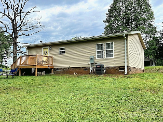 rear view of property featuring a lawn, a wooden deck, central AC, and crawl space