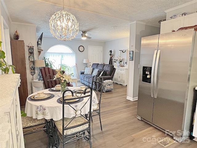 dining area with crown molding, a textured ceiling, ceiling fan with notable chandelier, and light wood-style flooring