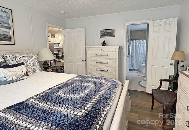 bedroom featuring crown molding, a textured ceiling, and wood finished floors