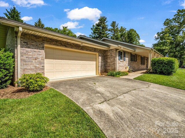 209 Daniel Dr, Hendersonville, NC 28739 - view of front of home featuring driveway, an attached garage, brick siding, and a front yard