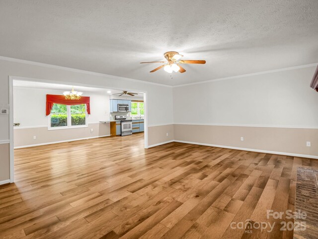 209 Daniel Dr, Hendersonville, NC 28739 - unfurnished living room featuring light wood-style floors, ceiling fan, a chandelier, baseboards, and ornamental molding