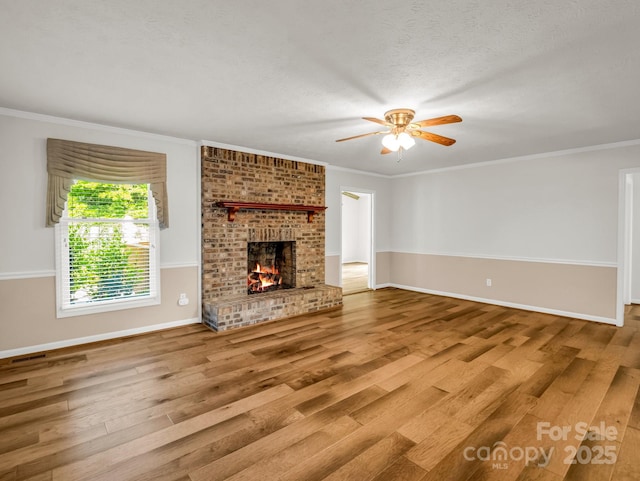 209 Daniel Dr, Hendersonville, NC 28739 - unfurnished living room with wood finished floors, a ceiling fan, baseboards, ornamental molding, and a fireplace