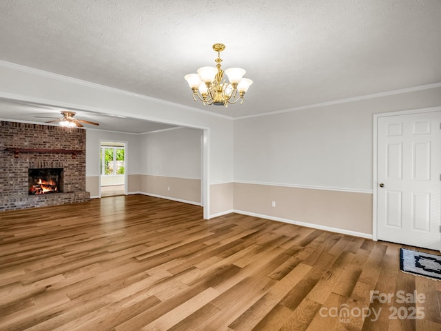 209 Daniel Dr, Hendersonville, NC 28739 - unfurnished living room featuring wood finished floors, a chandelier, ceiling fan, baseboards, and crown molding
