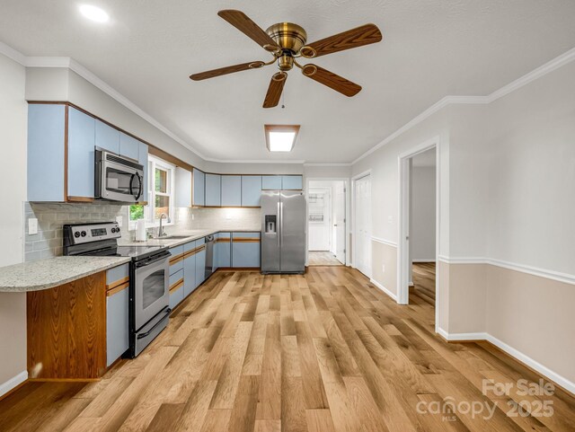 209 Daniel Dr, Hendersonville, NC 28739 - kitchen featuring appliances with stainless steel finishes, a sink, light wood-style floors, ornamental molding, and tasteful backsplash