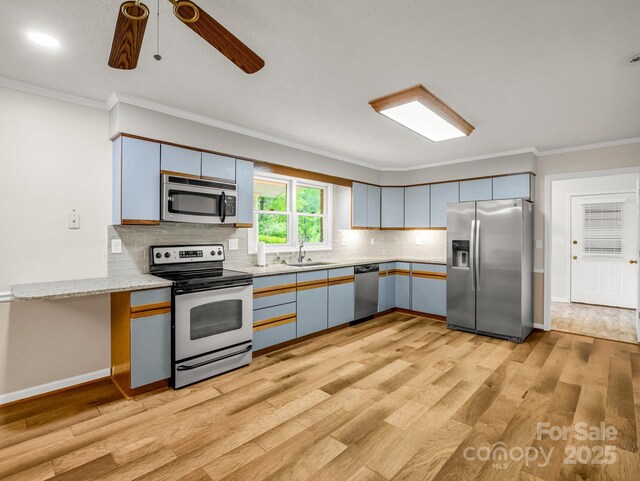 209 Daniel Dr, Hendersonville, NC 28739 - kitchen featuring stainless steel appliances, crown molding, a sink, decorative backsplash, and light wood finished floors
