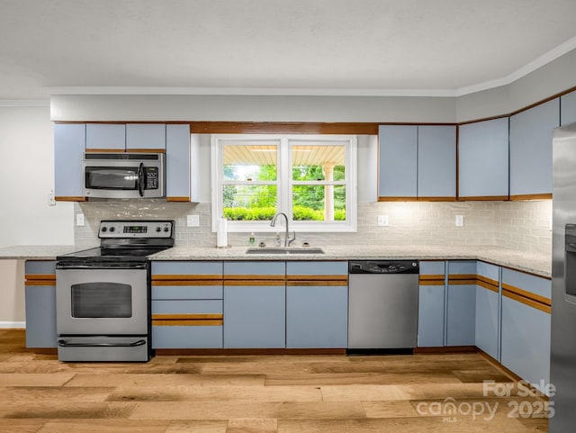 209 Daniel Dr, Hendersonville, NC 28739 - kitchen with appliances with stainless steel finishes, a sink, ornamental molding, light wood-style flooring, and light stone counters