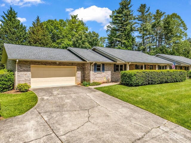 209 Daniel Dr, Hendersonville, NC 28739 - ranch-style house featuring brick siding, driveway, an attached garage, and a front lawn