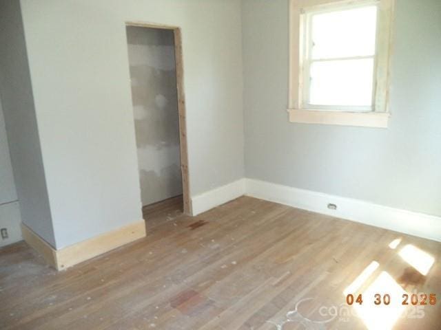 unfurnished bedroom with baseboards and wood finished floors