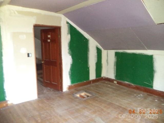 bonus room featuring vaulted ceiling and wood finished floors