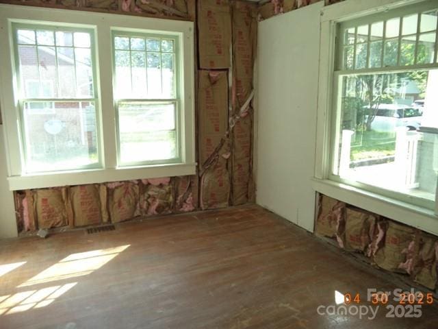 unfurnished room featuring visible vents and wood finished floors