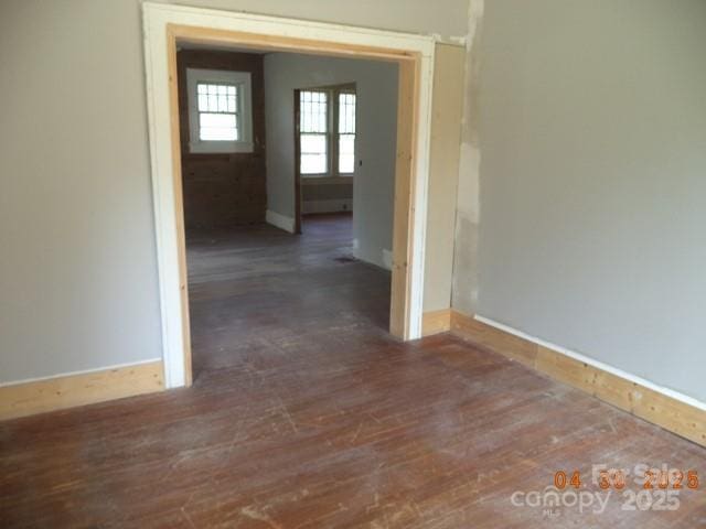 corridor featuring baseboards and wood finished floors