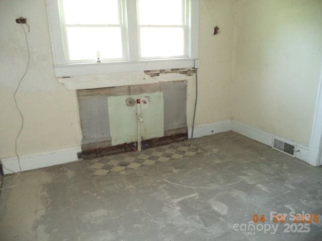 unfurnished room with visible vents