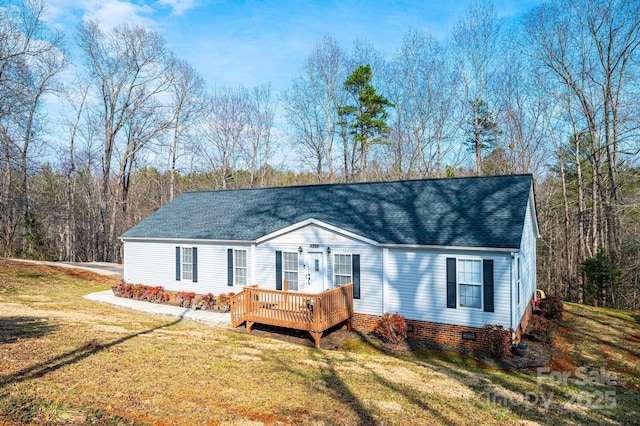 manufactured / mobile home featuring roof with shingles, crawl space, a deck, and a front lawn